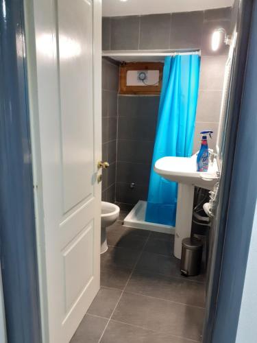 ein Badezimmer mit einem blauen Duschvorhang und einem Waschbecken in der Unterkunft Domvs 84 in Torre Annunziata