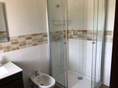 een badkamer met een douche, een toilet en een wastafel bij Moradia Gémea em Herdade Santa Marta in Zebreira