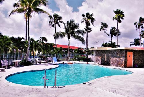a swimming pool at a resort with palm trees at Fairway Inn Florida City Homestead Everglades in Florida City