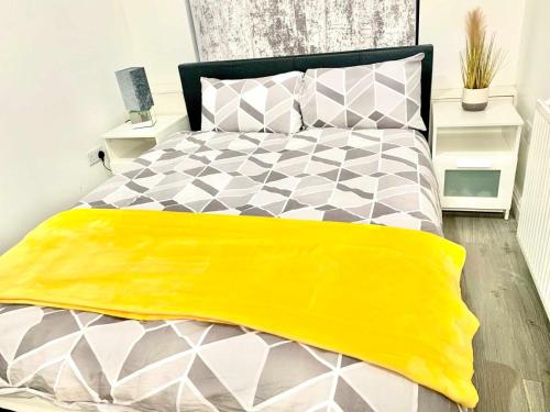 a bedroom with a bed with a yellow blanket on it at Kunda House Sparkbrook in Birmingham
