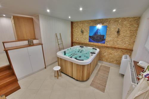 ein Bad mit einer Badewanne in einem Zimmer in der Unterkunft Gîte l'Authentique avec spa en option in Orschwiller