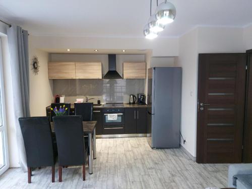 a kitchen and dining room with a table and a refrigerator at Apartament Luna in Szklarska Poręba