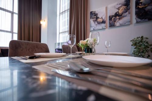 a dining room table with plates and wine glasses at Loft Pano Seaview Suite 2 Bedroom by The Only Bnb in Jelutong