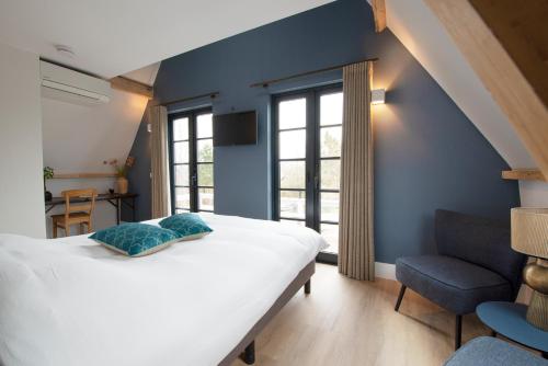 - une chambre avec un lit blanc et un mur bleu dans l'établissement The Lake Inn, à Nieuwkoop