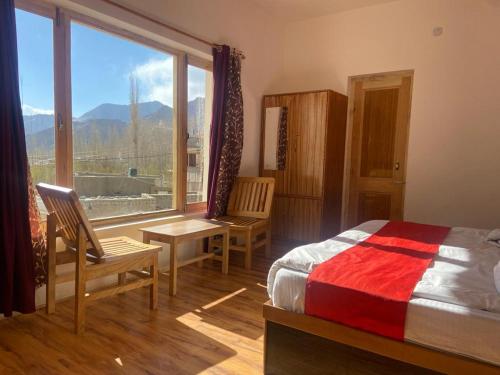 a bedroom with a bed and a large window at Nima's Villa in Leh