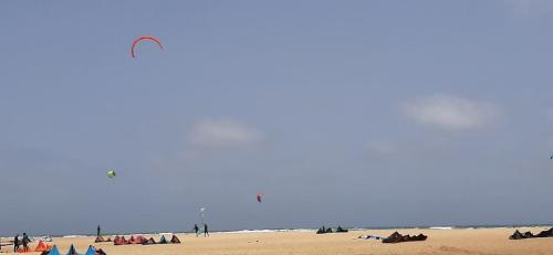 a group of people on a beach flying a kite at Atlantic Sal Hostel in Santa Maria