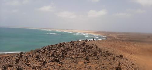 a group of people standing on top of a hill near the ocean at Atlantic Sal Hostel in Santa Maria