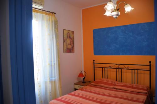 サン・ヴィート・ロ・カーポにあるCase Paseda Piazza Centraleの青とオレンジの壁のベッドルーム1室
