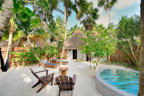 a resort with a hammock and a swimming pool at Maya Tulum By G Hotels in Tulum