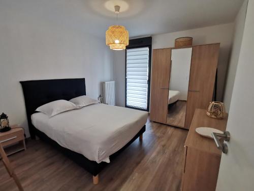 a bedroom with a large bed and a mirror at Les Ganivelles in Donville-les-Bains