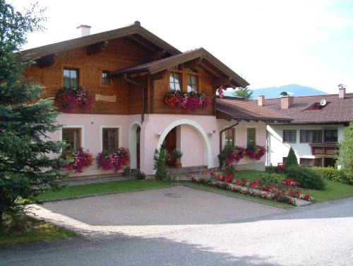 una casa con flores delante de ella en Haus Carina, en Flachau