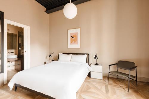 a bedroom with a large white bed and a chair at Sonder Barberini in Rome