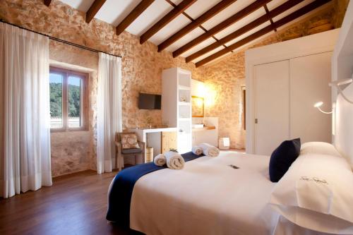 Un dormitorio con una gran cama blanca y una ventana en Agroturisme Son Samà, en Llucmajor