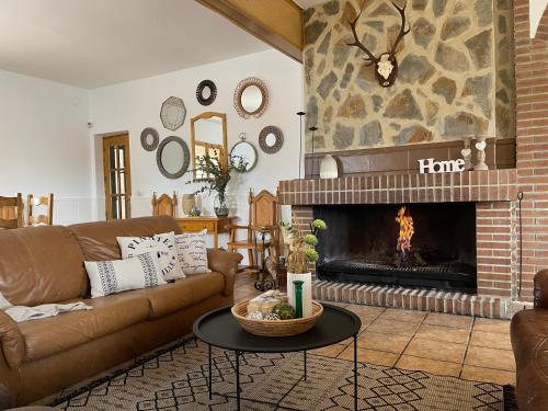 a living room with a couch and a fireplace at ESSE NATURA alojamientos & lifestyle in Pozohondo