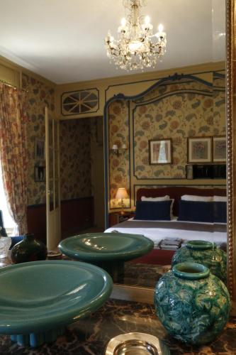 a bedroom with a bed and vases on a table at Chateau de Vaux in Yvré-lʼÉvêque