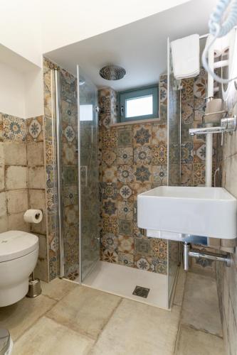 a bathroom with a sink and a toilet at RomAntica in Polignano a Mare