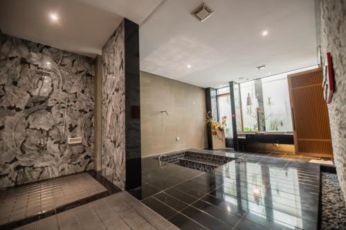 baño con pared de piedra y suelo de baldosa. en Ease Motel en Caotun