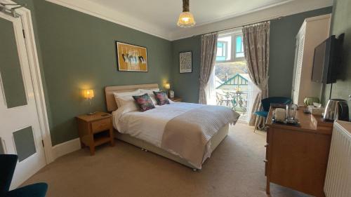 a bedroom with a bed and a large window at Southcliffe B&B in Lynton