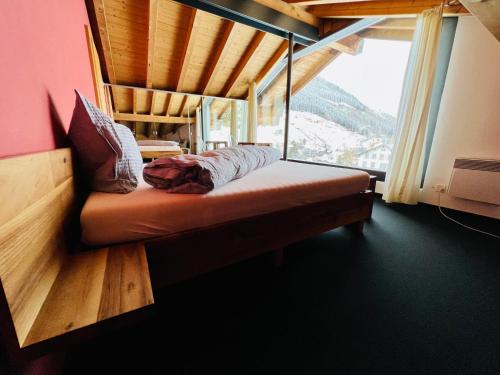 a bed in a room with a large window at Maisonette Franz in Vals