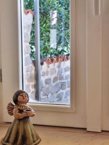 a small statue of a child standing in front of a window at Veneto in Perast