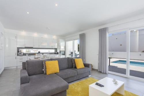 een woonkamer met een bank en een keuken bij Villa Dona Julia by Villa Plus in Carvoeiro