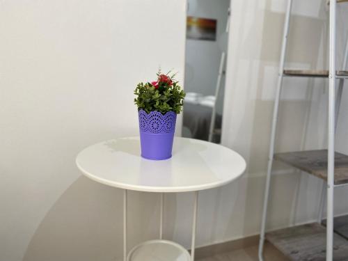 a blue vase on a white table with a plant at Bed & Breakfast La Rocca in Taormina