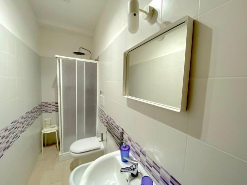 a white bathroom with a sink and a mirror at Bed & Breakfast La Rocca in Taormina