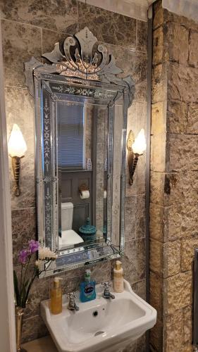 a bathroom with a sink and a mirror at Ravenscroft B&B in Mansfield