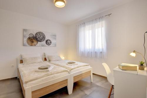 - une chambre blanche avec un lit et un bureau dans l'établissement Apartment Barbara, à Medulin