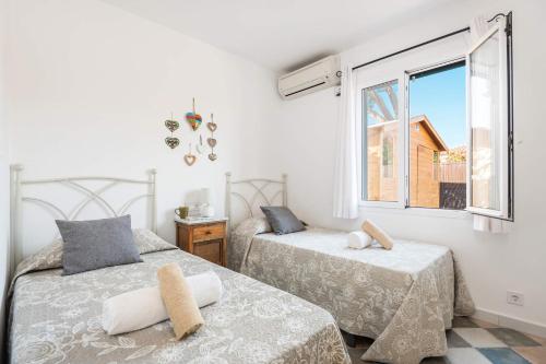 een slaapkamer met 2 bedden en een raam bij Villa Marina Way by Villa Plus in Sant Lluis