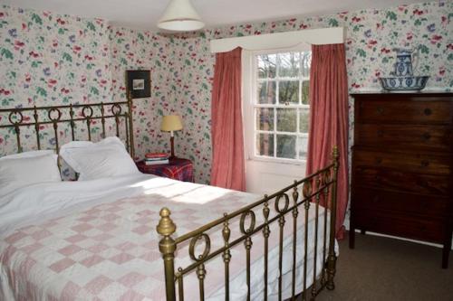 a bedroom with a bed and a window at Bittles Cottage in Dorchester