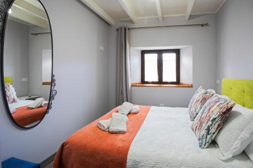 1 dormitorio con cama y espejo en Casa de campo en Llanes para 8 personas, en La Galguera