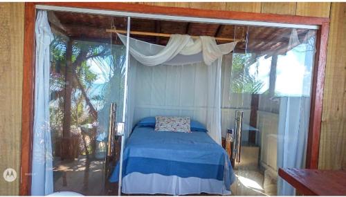 a bedroom with a canopy bed in a room at Chalé Antonella in Caraíva