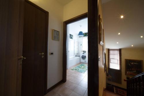 a hallway with a door leading to a bathroom at B&BMagicHouse in Novara