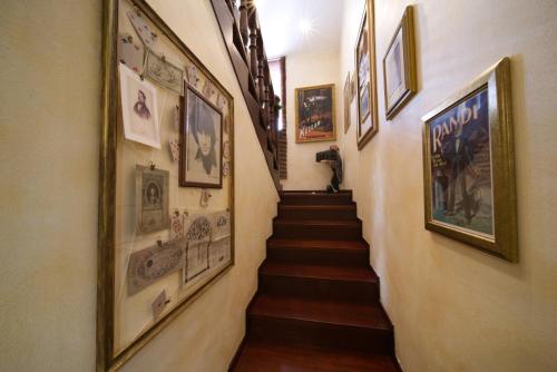 a hallway with a staircase with pictures on the walls at B&BMagicHouse in Novara