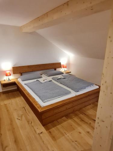 a large bed in a room with two lamps at Allgäuer Heimat in Rettenberg