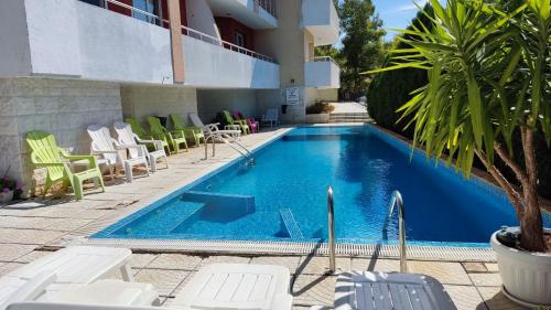 a large swimming pool with chairs and a hotel at Jeni's apartment in Kavarna