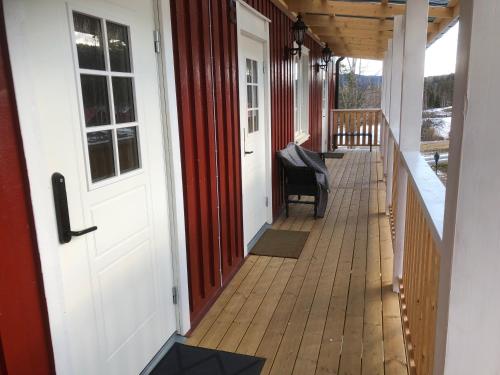 a porch of a house with a door and a chair at Järvsö Kramstatjärnsvägen 10E in Järvsö