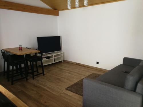 a living room with a couch and a table and a television at Casa Xavier in Ponta Delgada