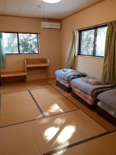 a room with two beds and two windows at Yasha Gami Hutte - Vacation STAY 36327v in Minami Alps