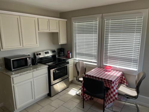 Near French Quarter Nice Two Bedrooms+ في نيو أورلينز: مطبخ مع دواليب بيضاء وطاولة مع مفرش