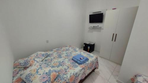 um quarto com uma cama com uma almofada em Suítes Privativas em Guriri em Guriri