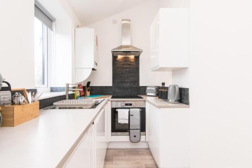 een keuken met witte werkbladen en een fornuis met oven bij Cricket View - Fabulous 1bed Apt near Trent Bridge Cricket Ground in Nottingham