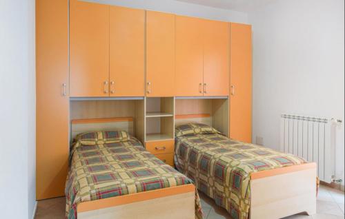2 camas en una habitación con armarios naranjas en Confortevole e Spazioso Appartamento 100mq a Falerna con Vista Panoramica sul Golfo con Free WiFi e Smart Tv, en Falerna