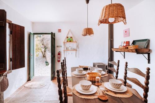 a dining room with a wooden table and chairs at Cá Vamos HORTACASA PORTUGAL in Santiago do Cacém