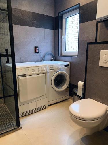a bathroom with a washing machine and a toilet at B Chez Hamdi in Knokke-Heist