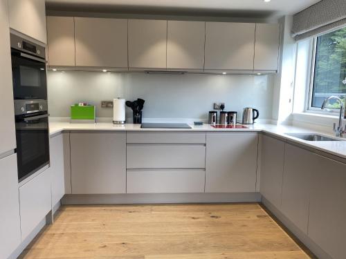 a kitchen with white cabinets and a sink at Charlecote House in Bath