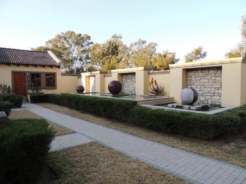 a house with hedges in front of a walkway at Strawberry Fields Country Manor Guest House in Johannesburg