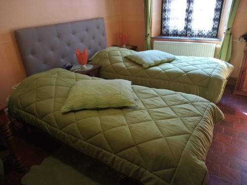 a bedroom with two beds and a head board at "A la douane" in Hestrud