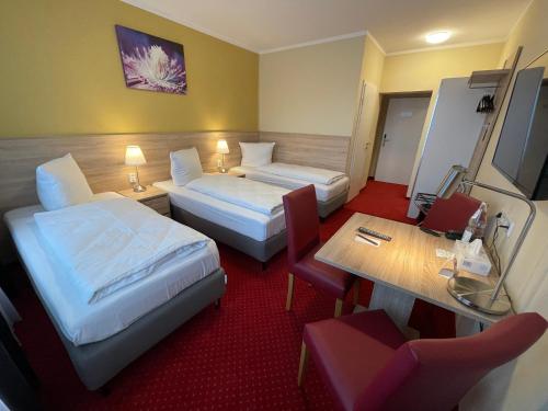a hotel room with two beds and a table at Palm Premium Hotel & Apartments in Düsseldorf